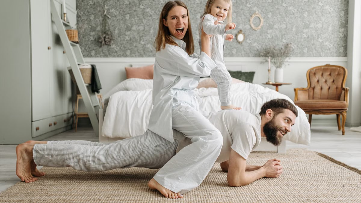 A cheerful family enjoys bonding and playing together on a cozy morning in a stylish bedroom.